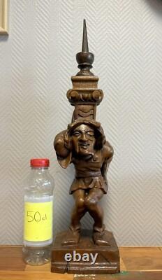 Carved wooden candle holder depicting a grotesque character, 19th century
