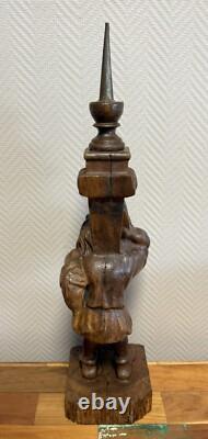 Carved wooden candle holder depicting a grotesque character, 19th century