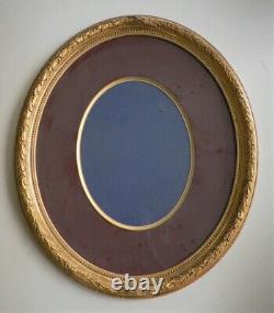 Nineteenth-century gilded gold Louis XVI medallion frame with laurel ribbon glass of the period