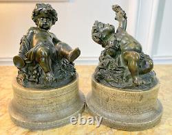 Pair of bronze patinated putti resting on marble bases from the 18th/19th century